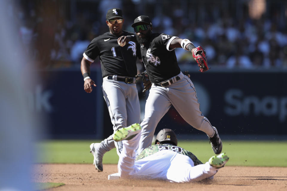 Chicago White Sox second baseman Josh Harrison, top right, prepares to throw to first to complete a double play after forcing out Juan Soto, bottom, at second on a ball hit by Manny Machado as White Sox's Elvis Andrus, top left, looks on during the sixth inning of a baseball game Sunday, Oct. 2, 2022, in San Diego. (AP Photo/Derrick Tuskan)