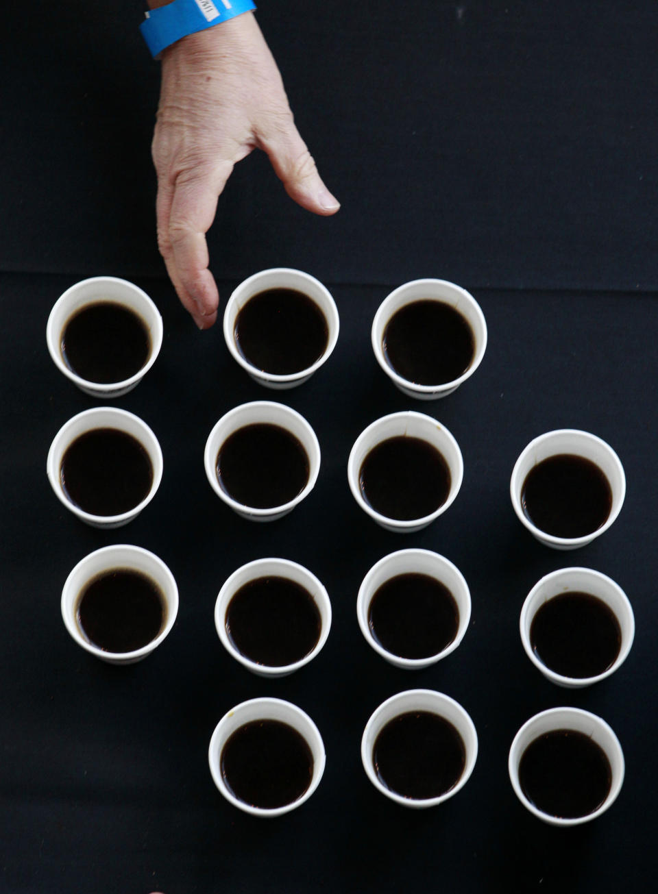 FILE - In this Wednesday, March 21, 2012 file photo, a person reaches for a cup of coffee before a meeting in Seattle. A large U.S. federal study concludes people who drink coffee seem to live a little longer. Researchers saw a clear connection between cups consumed and years of life. Whether it was regular or decaf didn't matter. The results are published in the Thursday, May 17, 2012 New England Journal of Medicine. (AP Photo/Elaine Thompson)