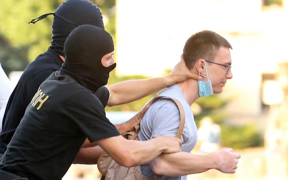 Law enforcement officers detain a person participating in the Ruki Peremen [Hands of Changes] opposition rally ahead of the presidential election  - GETTY IMAGES