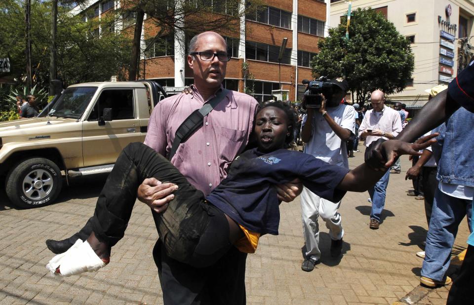 A journalist rescues a woman injured in a shootout between armed men and the police at the Westgate shopping mall in Nairobi September 21, 2013. (REUTERS/Thomas Mukoya)