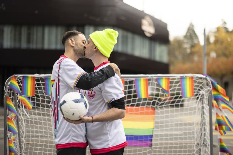 Unos manifestantes se besan mientras sostienen una pelota generar conciencia sobre la situación de los derechos humanos de las personas LGBT+ en Qatar y la responsabilidad de la FIFA, frente al Museo de la FIFA en Zúrich, Suiza, el martes 8 de noviembre de 2022. 