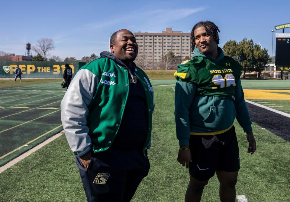 Marcus Green, left, the athletic director and head football coach at Cornerstone Lincoln-King High School, smiles as he stands next to Jordan Hutchinson during football practice at Wayne State University in Detroit on Friday, March 29, 2024.
