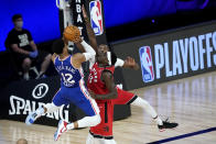 Philadelphia 76ers' Tobias Harris (12) goes up for a shot against Toronto Raptors' Pascal Siakam, center, and Chris Boucher during the first half of an NBA basketball game Wednesday, Aug. 12, 2020 in Lake Buena Vista, Fla. (AP Photo/Ashley Landis, Pool)