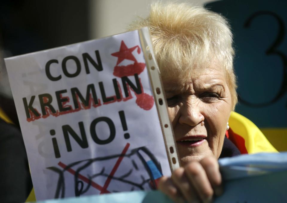 A protestor holds a sign against Russia in front of the foreign ministry in Madrid