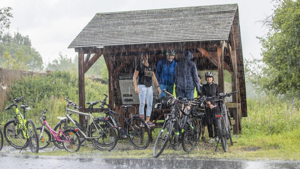 Ausflügler haben sich bei starkem Regen im Erzgebirge untergestellt.