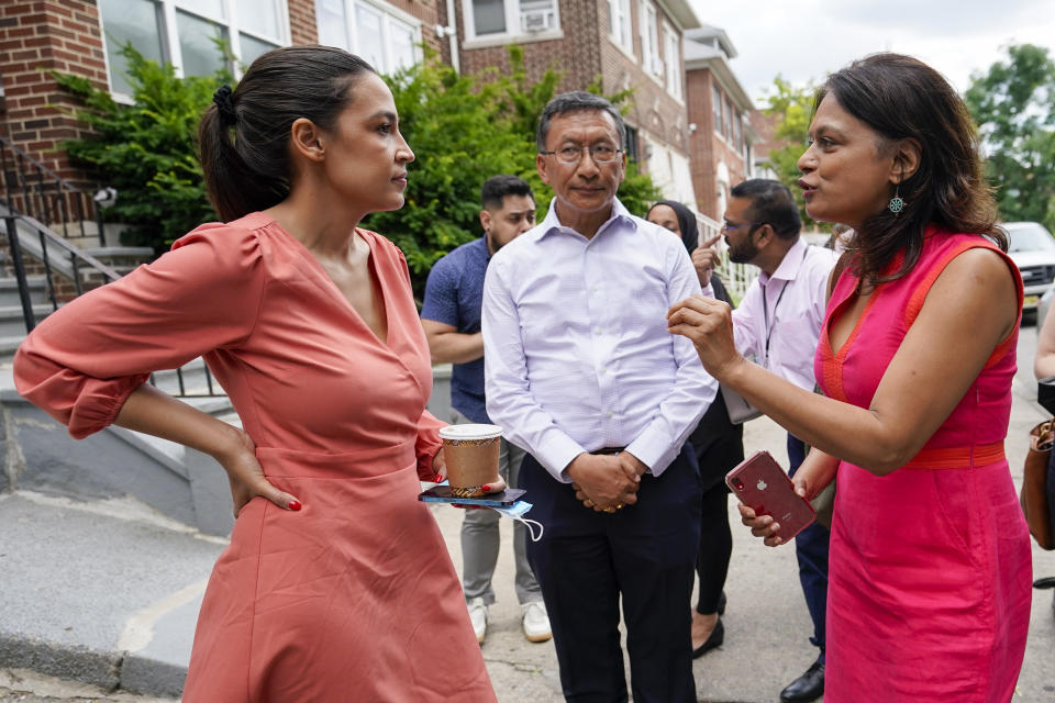 Rep. Alexandria Ocasio-Cortez, D-N.Y., left, speaks to Chhaya Community Development Corporation Executive Director Annetta Seecharran, left, and Urgen Sherpa, Wednesday, July 6, 2022, during a tour of the Jackson Heights neighborhood of the Queens borough of New York. As she seeks a third term this year and navigates the implications of being celebrity in her own right, she's determined to avoid any suggestion that she is losing touch with her constituents. (AP Photo/Mary Altaffer)
