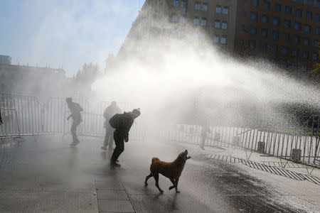 A jet of water is released on demonstrators during a protest calling for changes in the education system in Santiago, Chile April 11, 2017. REUTERS/Ivan Alvarado