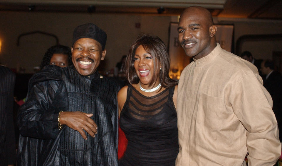 FILE - In this Feb. 20, 2003 file photo, Lloyd Price, left, and Mary Wilson, of the Supremes, pose for a photograph with boxer Evander Holyfield during the reception of the 13th Annual Pioneer Awards presented by the Rhythm & Blues Foundation in New York. The New Orleans mainstay and Rock and Roll Hall of Famer has died. Price was known for such hits as “Lawdy Miss Clawdy” and “Stagger Lee.” His wife Jackie said he died Monday, May 3, 2021 in New Rochelle, N.Y. (AP Photo/Frank Franklin II, File)