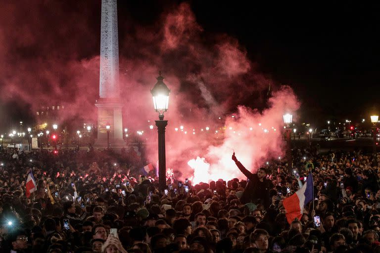 Aficionados encienden bengalas mientras esperan en la Plaza de la Concordia la llegada de la selección francesa de fútbol al Hotel de Crillon, un día después del partido de la final de la Copa del Mundo Qatar 2022 contra Argentina, en el centro de París el 19 de diciembre de 2022.