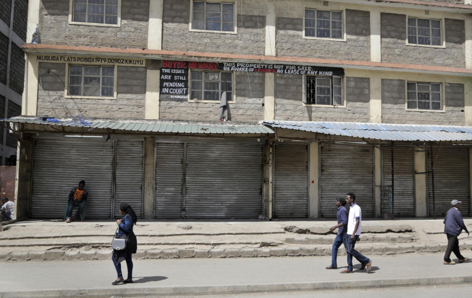 Kenyans walk past closed shops in the Eastleigh area of the capital, after members of the business community there closed the shops as a protest to condemn Tuesday's attack on a hotel complex, in Nairobi, Kenya, Friday, Jan. 18, 2019. Extremists stormed a luxury hotel complex in Kenya's capital on Tuesday, setting off explosions and gunning down people at cafe tables in an attack claimed by militant group al-Shabab. (AP Photo/Khalil Senosi)