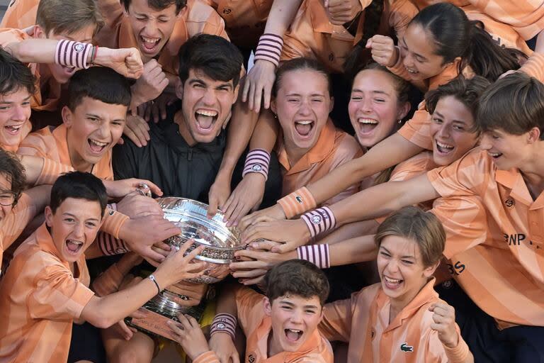 Carlos Alcaraz celebra la conquista del título en París junto a los chicos y las chicas alcanzapelotas