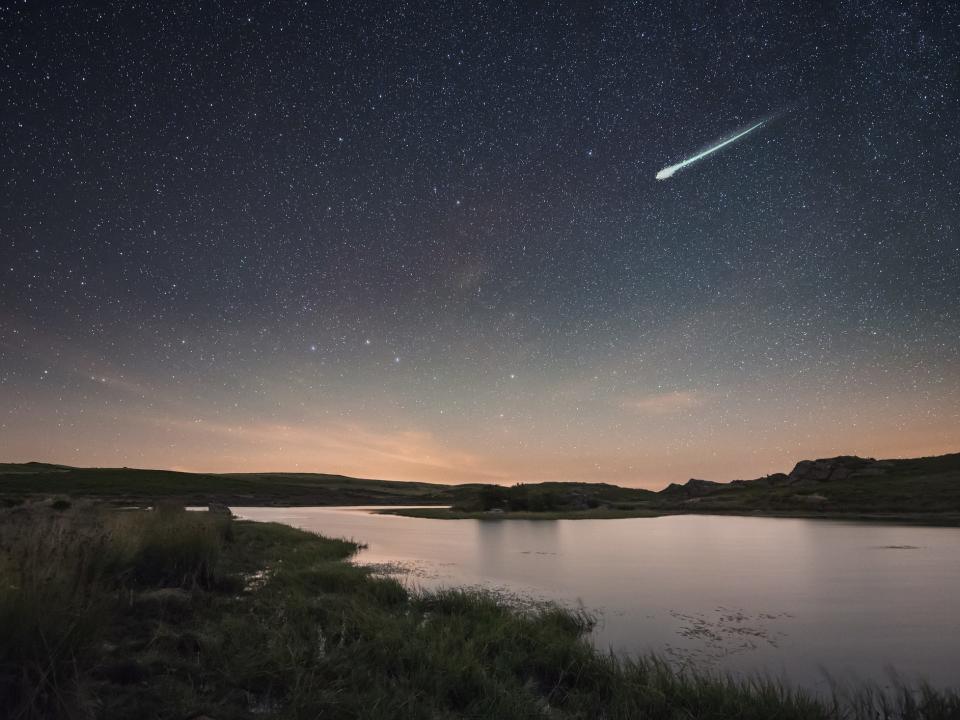 A big fireball is seen streaking over a lake in the early hours of the day.