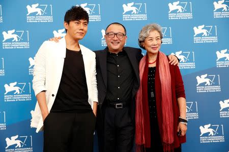 Director Wang Xiaoshuai (C) poses with cast members Qin Hao (L) and Lu Zhong during the photo call for the movie "Chuangru zhe" (Red amnesia) at the 71st Venice Film Festival September 4, 2014. REUTERS/Tony Gentile