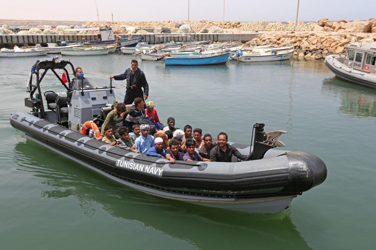 Migrants rescued by Tunisia's national guard during an attempted crossing of the Mediterranean by boat arrive at the port of el-Ketef in Ben Guerdane in southern Tunisia near the border with Libya on June 27, 2021. - Tunisia's defence ministry said Sunday that its navy had rescued 178 migrants who were trying to cross the Mediterranean from Libya to reach Europe. The migrants, who the ministry said were from Egypt, Tunisia, Syria, Ivory Coast, Bangladesh, Nigeria, Mali and Ethiopia, had set off from the Libyan port of Zuwara overnight Friday to Saturday. (Photo by FATHI NASRI / AFP) (Photo by FATHI NASRI/AFP via Getty Images)