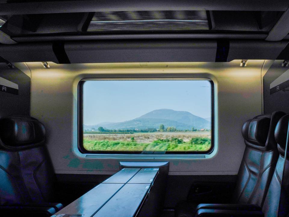 Inside a train car in Italy with a view of mountains out the window