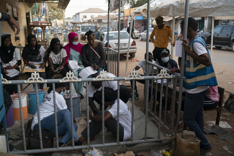 Electoral workers use a counting board to tally marbles from one polling station during Gambia's presidential elections in Serrekunda, Gambia, Saturday, Dec. 4, 2021. Gambians vote in a historic election, one that for the first time will not have former dictator Yahya Jammeh appearing on the ballot. (AP Photo/Leo Correa)