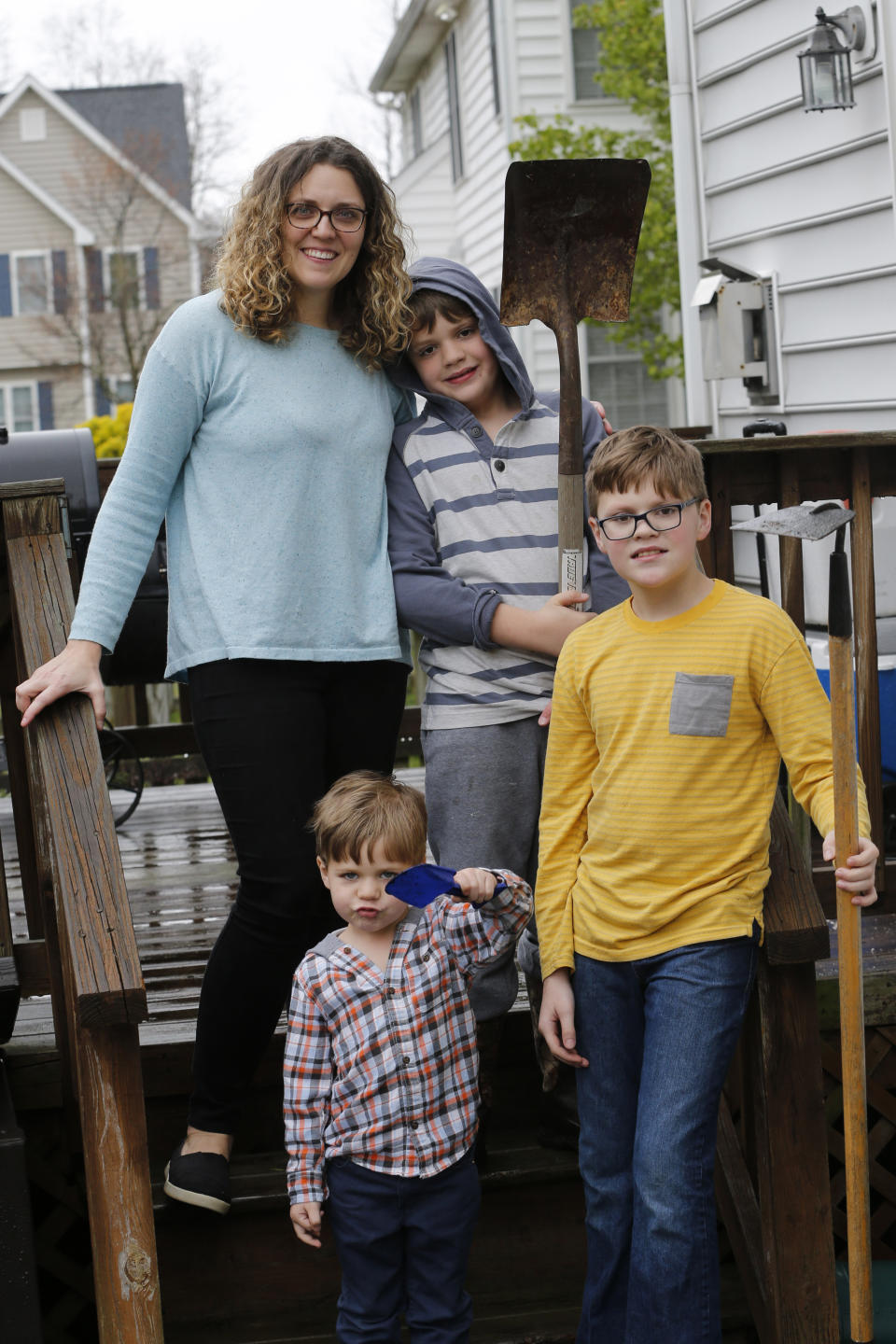 Stephanie Owens and her three children Lucas, 12: Reid, 8; and Cole, 3. Tend to a small garden at their home Wednesday March 25 , 2020, in Glen Allen, Va. Owens is a pharmacist who has had to continue to go to work, but has been able to spend more time with her kids because they are home from school . One of the activities that they have done is planting the garden. (AP Photo/Steve Helber)