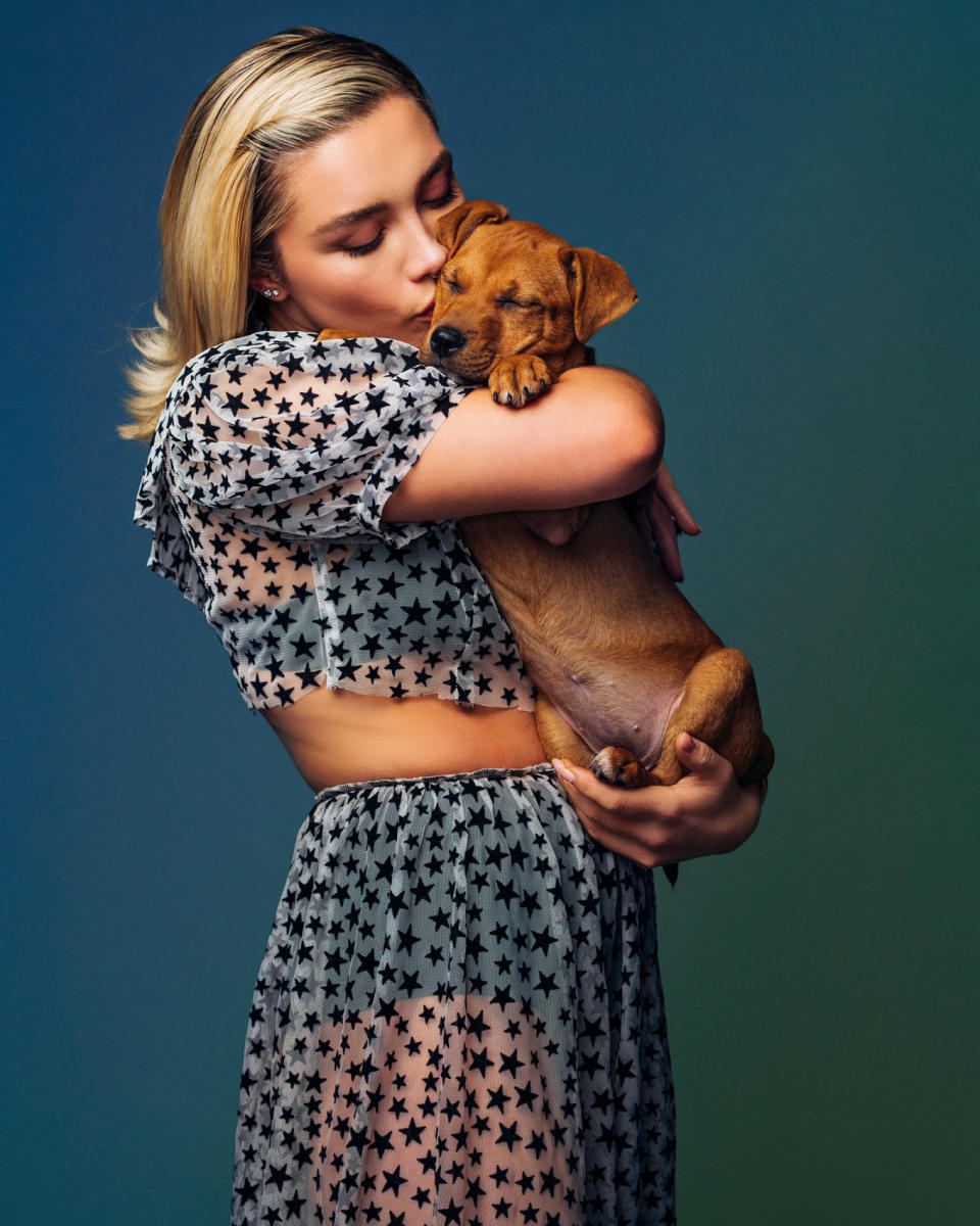 Flo holding and kissing a puppy