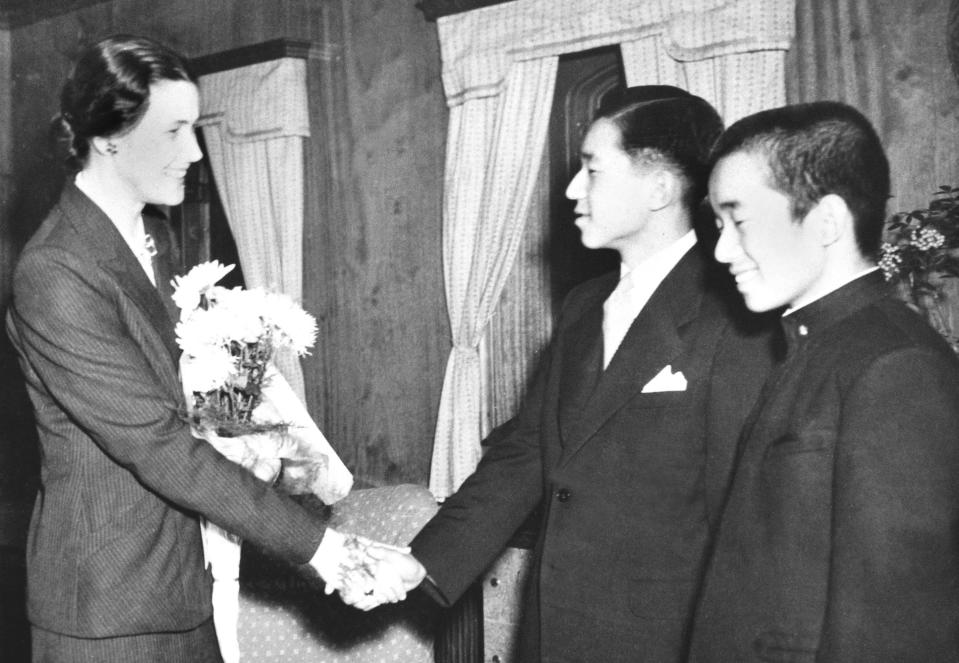 In this Dec. 1, 1950, photo, then Crown Prince Akihito, second from right, shakes hands with his tutor Elizabeth Vining as Vining bids a farewell to him in Yokohama. During the U.S. occupation of Japan after the end of the World War II, he was tutored in English by Elizabeth Vining, a Quaker, an experience that experts say gave Akihito his pacifist and democratic outlook. At right is his brother Prince Yoshinomiya (Kyodo News via AP)