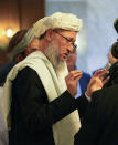 Abdul Salam Hanafi, a deputy prime minister in the Taliban's interim government, left, speaks to members of his delegation during talks involving Afghan representatives in Moscow, Russia, Wednesday, Oct. 20, 2021. Russia hosted talks on Afghanistan on Wednesday involving senior representatives of the Taliban and neighboring nations, a round of diplomacy that underlines Moscow's clout. Russian Foreign Minister Sergey Lavrov opened the talks and emphasized that "forming a really inclusive government fully reflecting the interests of not only all ethnic groups but all political forces of the country" is necessary to achieve a stable peace in Afghanistan. (AP Photo/Alexander Zemlianichenko, Pool)