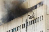 RNPS - PICTURES OF THE YEAR 2013 - A man falls from a high floor of a burning building in central Lahore May 9, 2013. Fire erupted on the seventh floor of the LDA plaza in Lahore and quickly spread to higher floors leaving many people trapped inside the building. At least three people fell from the high floors trying to avoid the fire that engulfed the building, local media reports. REUTERS/Damir Sagolj (PAKISTAN - Tags: SOCIETY DISASTER TPX)
