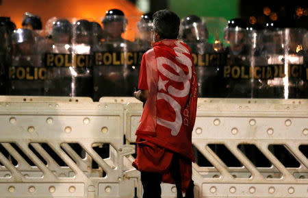 A demonstrator stands in front of police officers during a protest against the impeachment of President Dilma Rousseff in Brasilia, Brazil, May 11, 2016. REUTERS/Paulo Whitaker