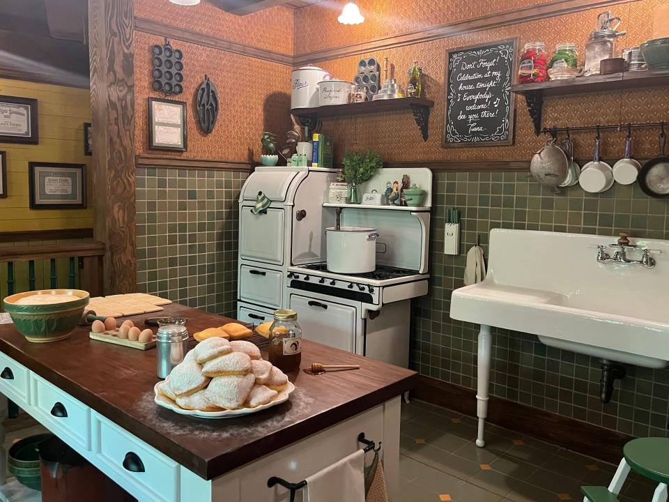 tiana's kitchen with beignets on the counter in the line area for tiana's bayou adventure