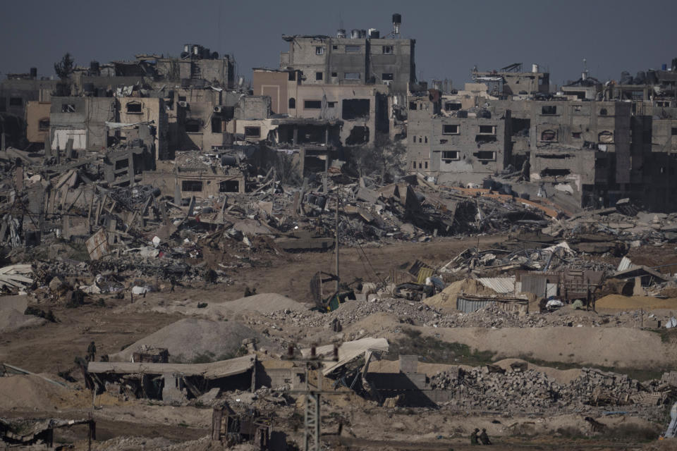 Israeli troops walk in the Gaza Strip as seen from southern Israel, Thursday, Dec. 21, 2023. The army is battling Palestinian militants across Gaza in the war ignited by Hamas' Oct. 7 attack into Israel. (AP Photo/Leo Correa)