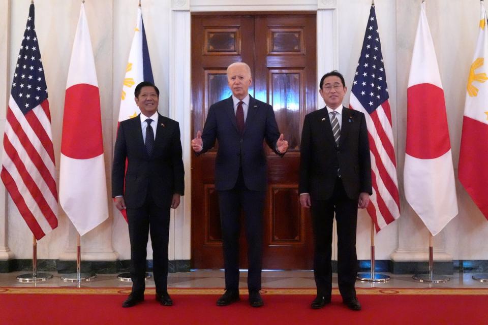 President Joe Biden, center, speaks alongside Philippine President Ferdinand Marcos Jr., left, and Japanese Prime Minister Fumio Kishida before a trilateral meeting (AP)