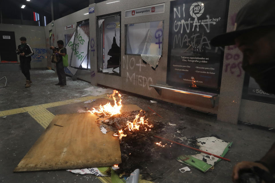 Debris burns at a bus station after protesters trashed the station during a women's march sparked by a string of alleged sexual attacks by police officers, in Mexico City, Friday, Aug. 16, 2019. On Friday, hundreds of women demonstrated largely peacefully in downtown Mexico City with pink spray paint and smoke. This week, an auxiliary policeman was held for trial on charges he raped a young female employee at a city museum. (AP Photo/Marco Ugarte)