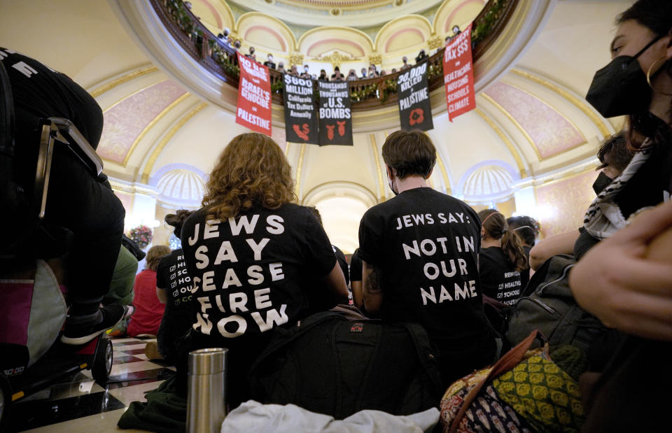 Protesters calling for a cease-fire in Gaza gather in the rotunda of the Capitol during the first day of the California legislative session in Sacramento, Calif., Wednesday, Jan. 3, 2024. The Assembly session was just just getting started when protesters wearing matching black t-shirts stood up in the gallery and started singing "Cease-fire now" and "Let Gaza Live." The Assembly adjourned the session.(AP Photo/Rich Pedroncelli)