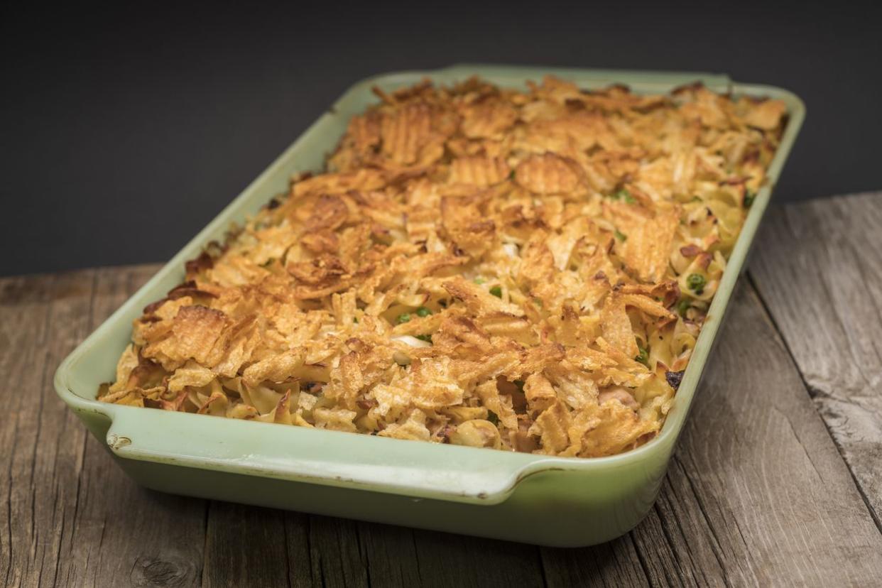 Tuna casserole topped with potato chips in light green ceramic baking dish