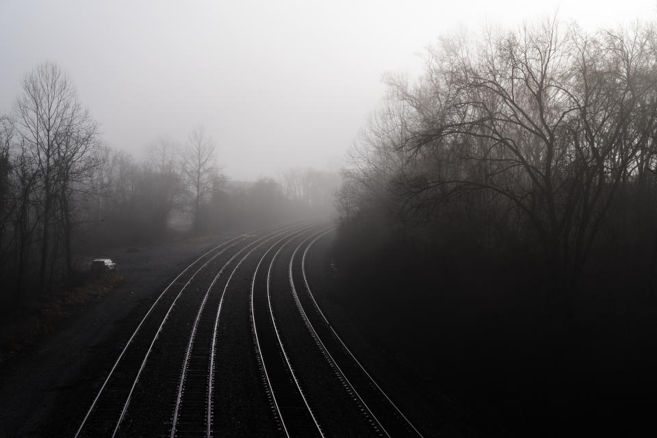 A police patrol vehicle sits along a stretch of railroad tracks in Huntington, W.Va., Wednesday, March 17, 2021. Huntington was once a thriving industrial town of almost 100,000 people. It sits at the corner of West Virginia, Kentucky and Ohio, and the railroad tracks through town used to rumble all day from trains packed with coal. Then the coal industry collapsed, and the trains don't come so much anymore. (AP Photo/David Goldman)