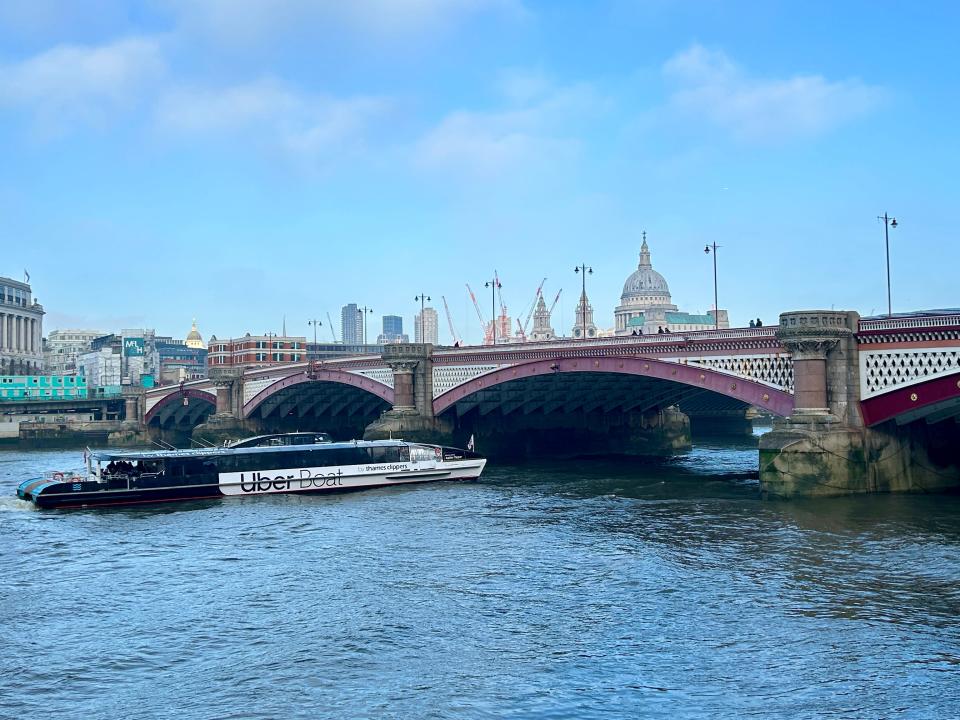 uber boat on the Thames crossing under a bridge