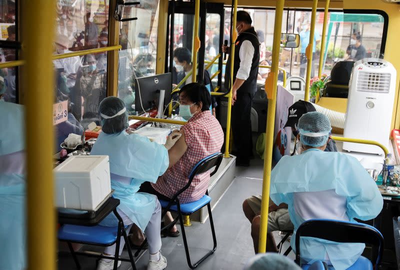 Woman receives a jab of the coronavirus disease (COVID-19) vaccine inside a mobile vaccination bus set-up to serve the elderly and disabled groups in Bangkok