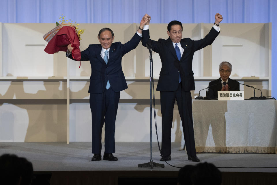 Japanese former Foreign Minister Fumio Kishida, right, celebrates with outgoing Prime Minister Yoshihide Suga after being announced the winner of the Liberal Democrat Party leadership election in Tokyo Wednesday, Sept. 29, 2021. Kishida won the governing party leadership election on Wednesday and is set to become the next prime minister, facing the imminent task of addressing a pandemic-hit economy and ensuring a strong alliance with Washington to counter growing regional security risks. (Carl Court/Pool Photo via AP)