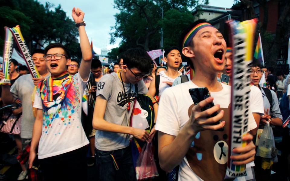 Same-sex marriage supporters cheer after the Constitutional Court ruled in favor of same-sex marriage outside the Legislative Yuan in Taipei, Taiwan, Wednesday - Credit: Chiang Ying-ying/AP