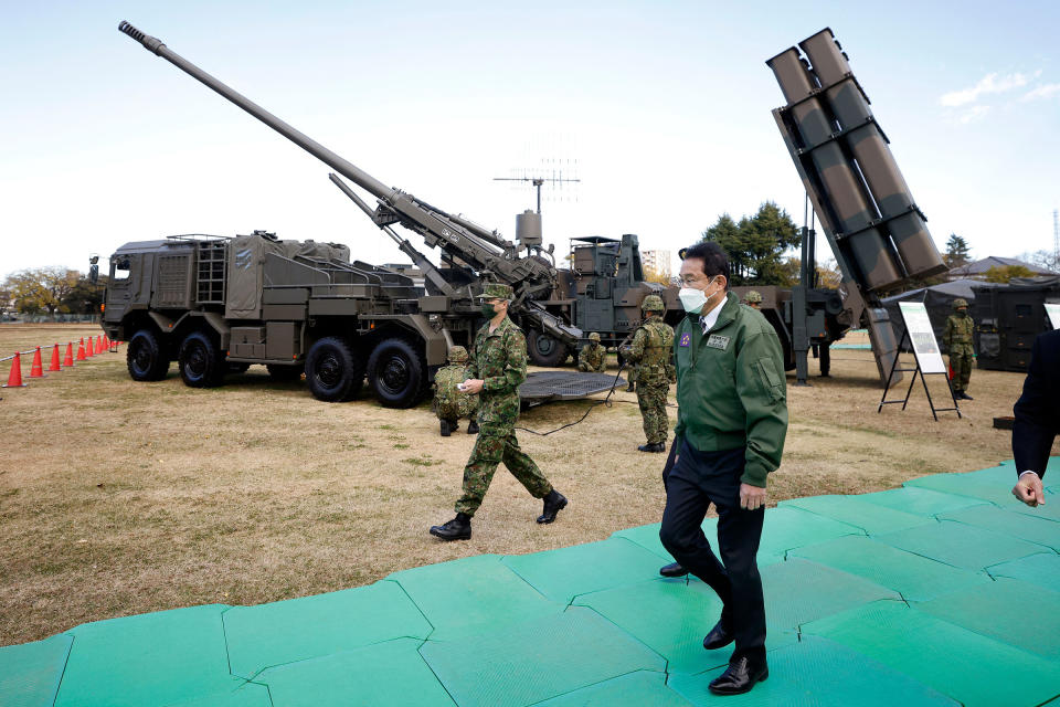 Prime Minister Kishida walks past a Japan Ground Self-Defense Force (JGSDF) Type 19 155 mm wheeled self-propelled howitzer and a Type 12 surface-to-ship missile as he inspects equipment during a review at JGSDF Camp Asaka in Tokyo on Nov. 27, 2021.<span class="copyright">Kiyoshi Ota—Pool/AFP/Getty Images</span>