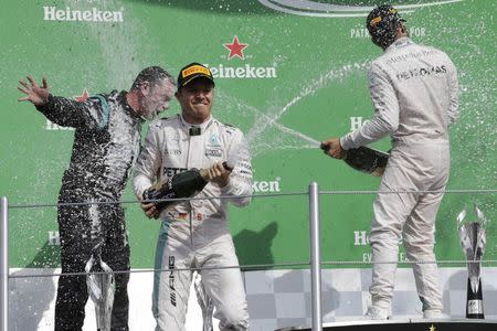 Formula One - F1 - Mexican F1 Grand Prix - Mexico City, Mexico - 30/10/16 - Second placed finisher Mercedes driver Nico Rosberg of Germany (C) and his teammate, race winner Lewis Hamilton of Britain (R), spray champagne with Paddy Lowe (L), engineer, technical director of Mercedes, during the victory ceremony after the race. REUTERS/Henry Romero