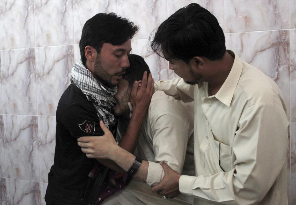 Men mourn the death of a relative, who was killed with two others by unidentified gunmen, in a hospital Quetta, Pakistan, July 6, 2015. A policeman and two others were killed when unidentified assailants opened fire on them near the passport office at Joint Road in Quetta on Monday, according to the police. REUTERS/Naseer Ahmed TPX IMAGES OF THE DAY