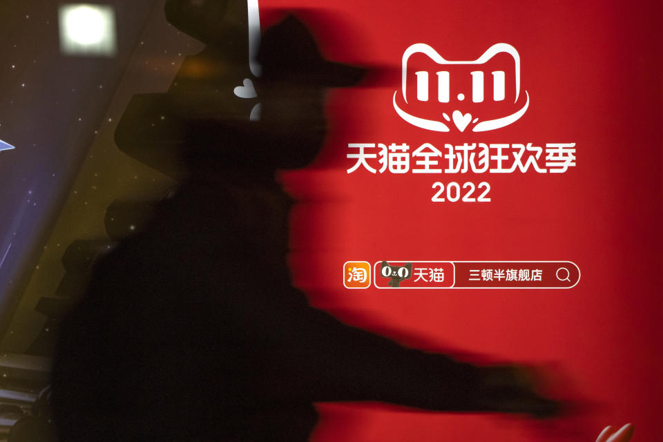 A cyclist rides past an advertisement for Tmall's Singles' Day sale at a bus stop in Beijing, Wednesday, Nov. 9, 2022. China's biggest online shopping festival, known as Singles' Day, is typically an extravagant affair as Chinese e-commerce firms like Alibaba and JD.com ramp up marketing campaigns and engage top livestreamers to hawk everything from lipstick to furniture as they race to break sales records of previous years. (AP Photo/Mark Schiefelbein)