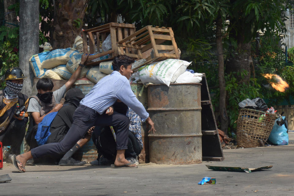 An anti-coup protester throws a Molotov cocktail to confront police in Yangon, Myanmar Sunday, March 28, 2021. Protesters in Myanmar returned to the streets Sunday to press their demands for a return to democracy, just a day after security forces killed more than 100 people in the bloodiest day since last month's military coup. (AP Photo)