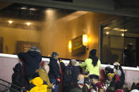 Fans looking into one of the skybox suites at FedEx Field as water enters from the ceiling during the first half of an NFL football game between the Seattle Seahawks and Washington Football Team, Monday, Nov. 29, 2021, in Landover, Md. (AP Photo/Nick Wass)