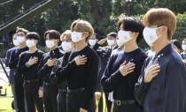 South Korean K-pop group BTS members salute to their national flag during a ceremony marking the National Youth Day at the presidential Blue House in Seoul, South Korea, Saturday, Sept. 19, 2020. (Lee Jin-wook/Yonhap via AP)