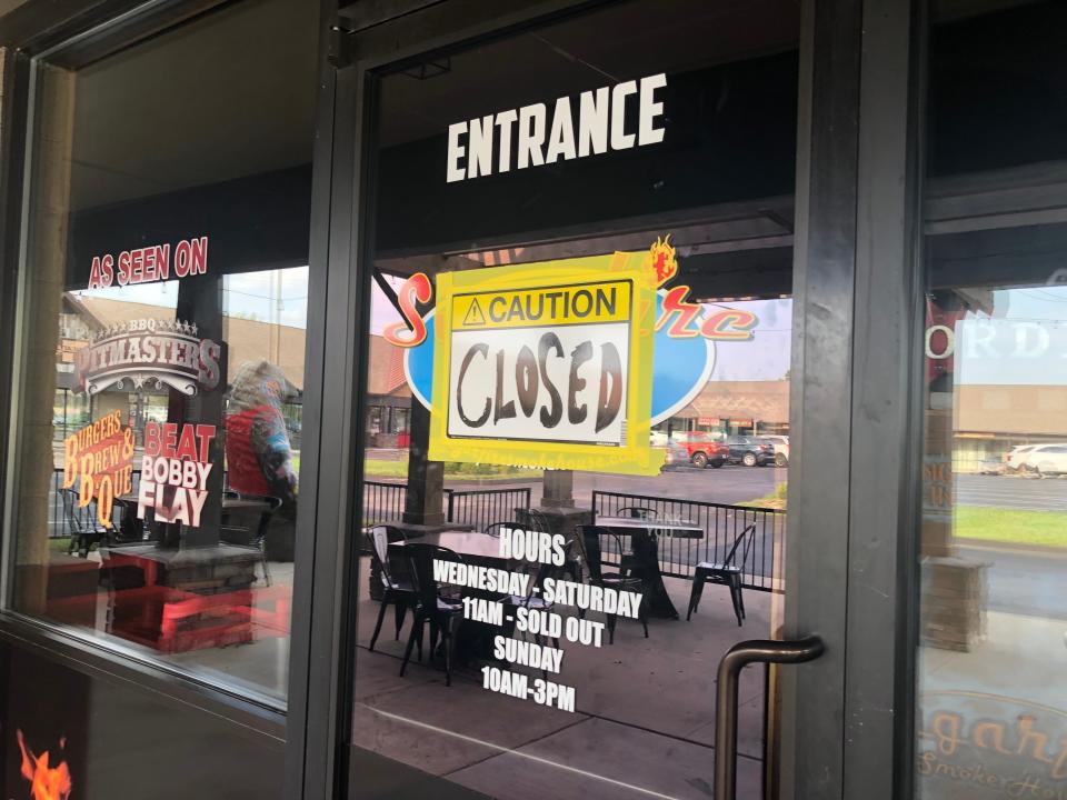 A hand-lettered "CLOSED" sign is taped to the entrance of Sugarfire Smoke House, 1730 E. Republic Road, on Aug. 23, 2023.