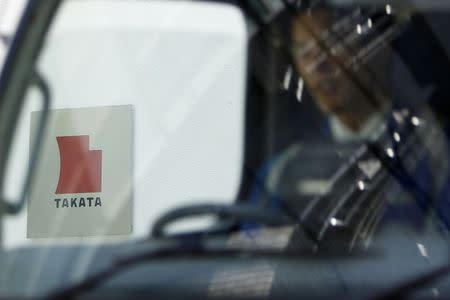 A logo of Takata Corp is seen through a car window outside the company's headquarters building in Tokyo in this April 12, 2013 file photo. REUTERS/Yuya Shino/Files