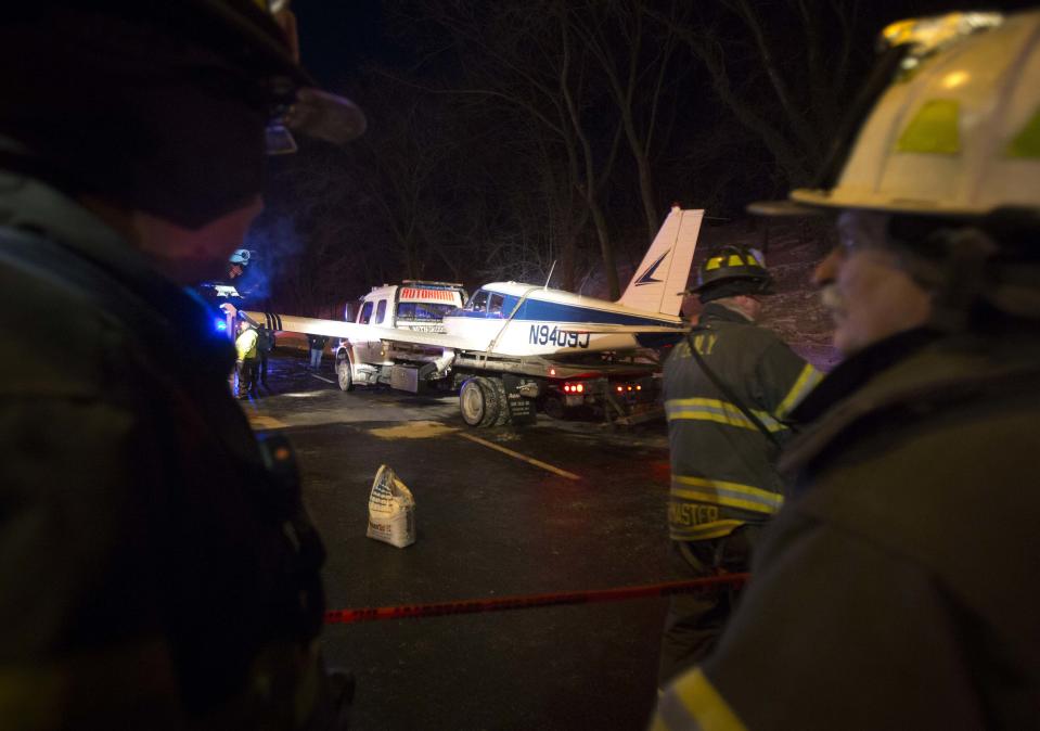 A single engine plane is loaded onto a flat bed truck after landing on Major Deegan Expressway in the Bronx borough of New York