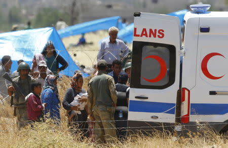 Syrian Kurds from Kobani who need medical help are taken to an ambulance on the Turkish-Syrian border in Suruc in Sanliurfa province, Turkey, June 26, 2015. REUTERS/Murad Sezer