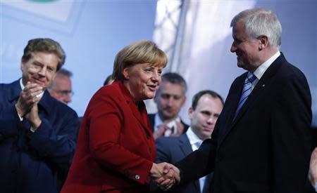 German Chancellor Angela Merkel and Bavarian state Premier Horst Seehofer shake hands after a Christian Democratic Union election campaign meeting in Augsburg September 19, 2013. REUTERS/Michael Dalder