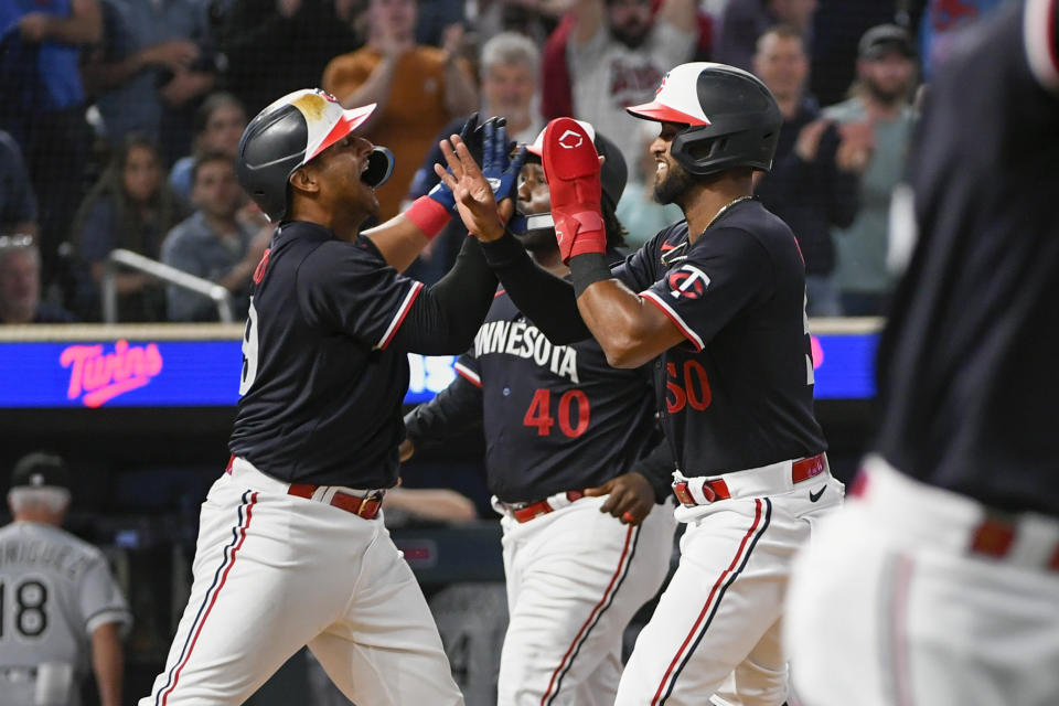 Minnesota Twins' Willi Castro right, celebrates with Donovan Solano after scoring on a throwing error by Chicago White Sox pitcher Jesse Scholtens during the 10th inning of a baseball game Tuesday, April 11, 2023, in Minneapolis. (AP Photo/Craig Lassig)